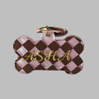 Checkered bone-shaped keychain with gold text on a light blue background